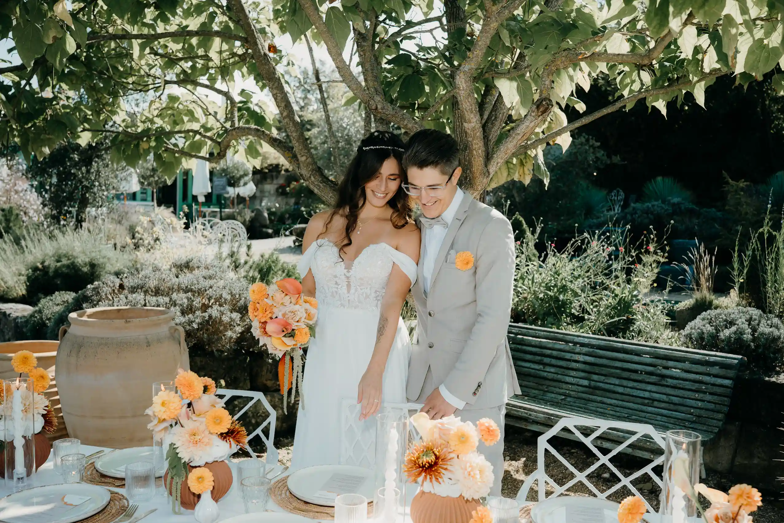 Brautpaar an stilvoll dekoriertem Hochzeitstisch mit orangefarbener Eventfloristik und modernem Hochzeitsdesign von RICH EVENTS in Franken