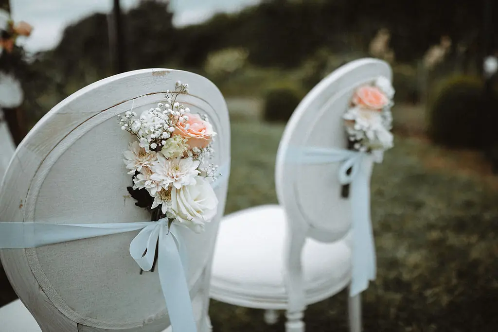 Blumendeko an Brautstühlen bei freier Trauung auf Schloss Walkershofen