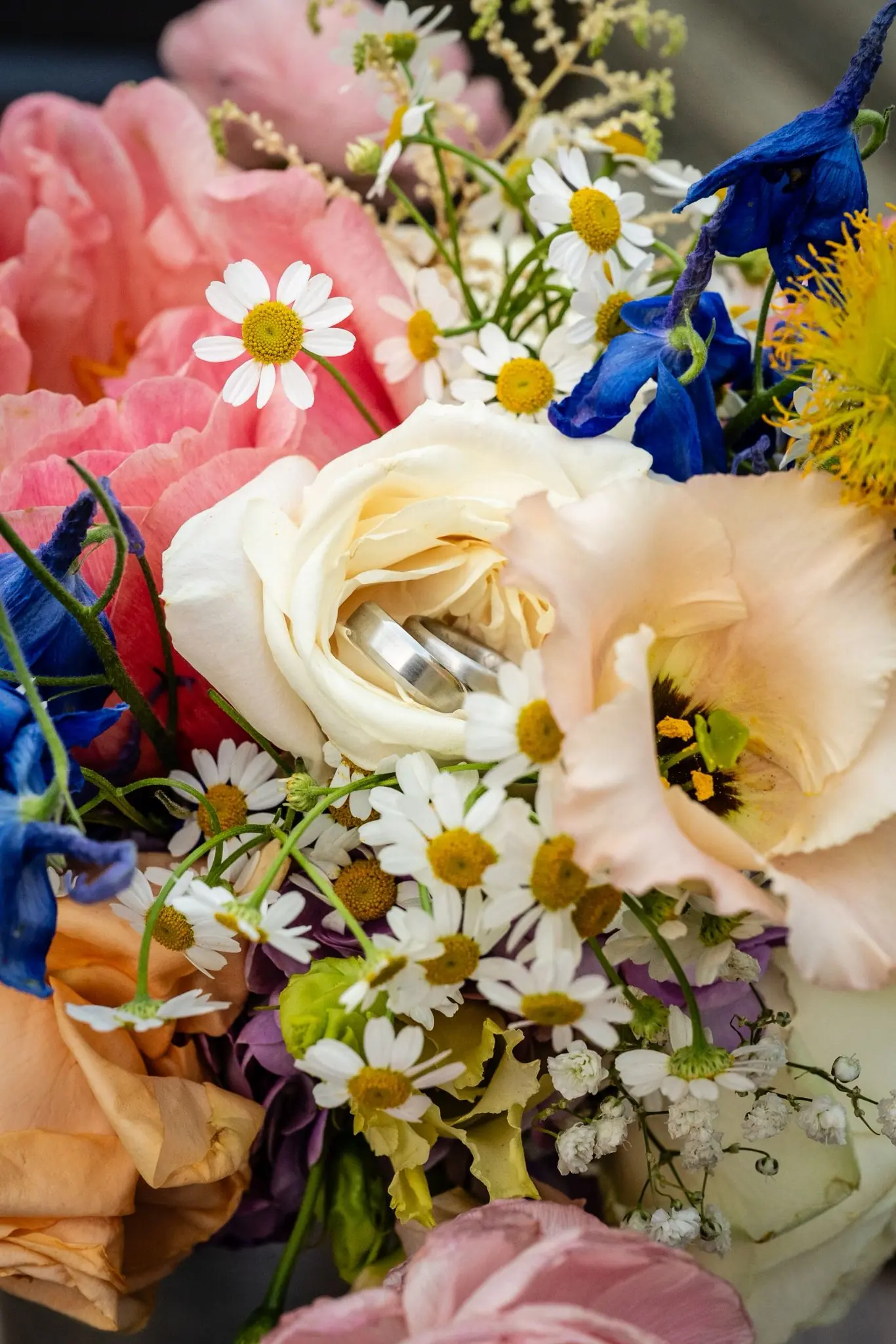 Bunte Blüten des Brautstraußes mit Ringen