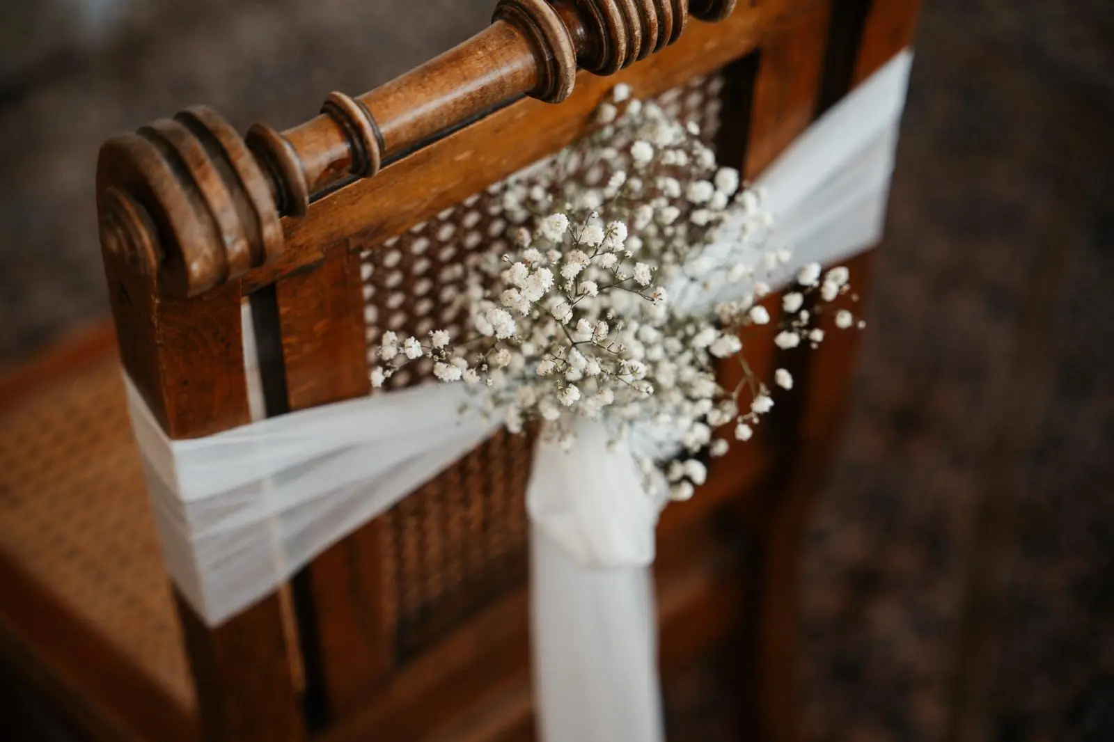 Brautstuhldekoration mit Schleife und Schleierkraut