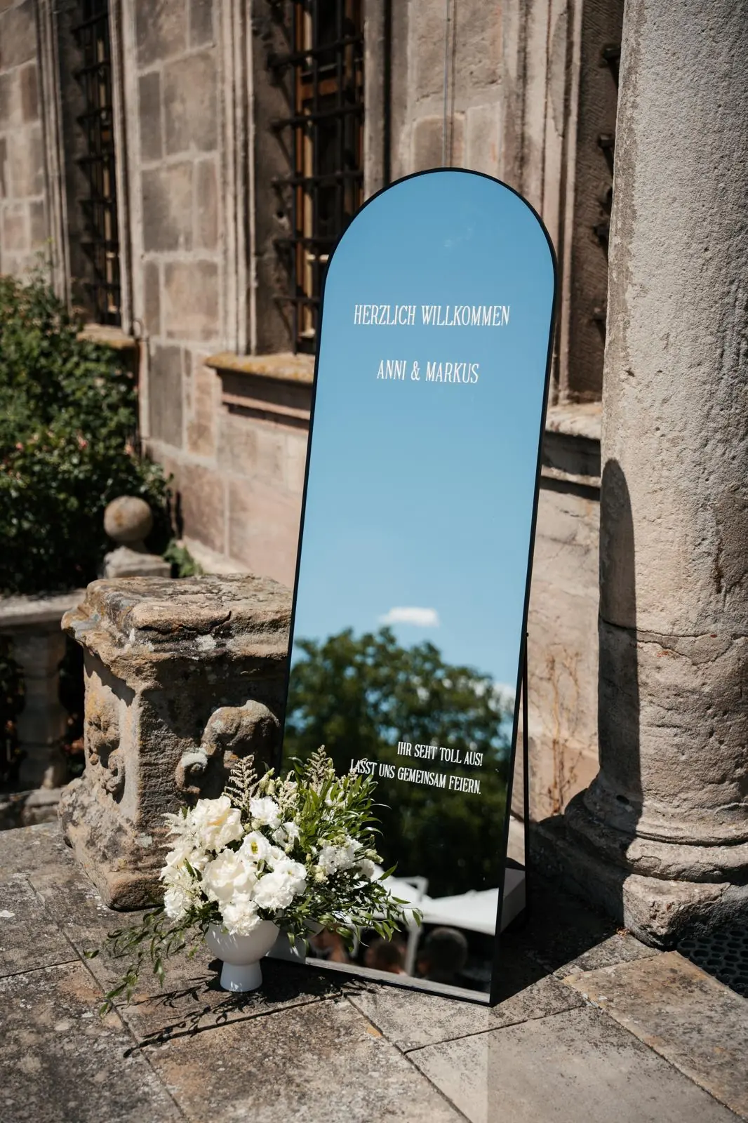 Willkommensschild Spiegel mit weißen Rosen und Schleierkraut vor Kapelle