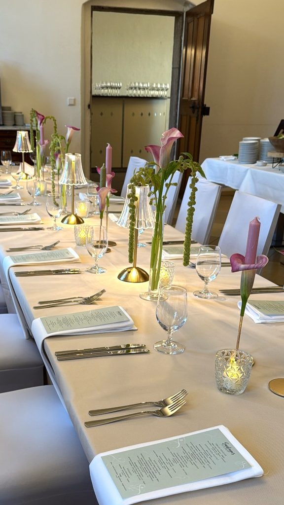 Elegante Hochzeitstafel mit pinkfarbenen Callas und goldenen Tischleuchten im Schloss Hemhofen