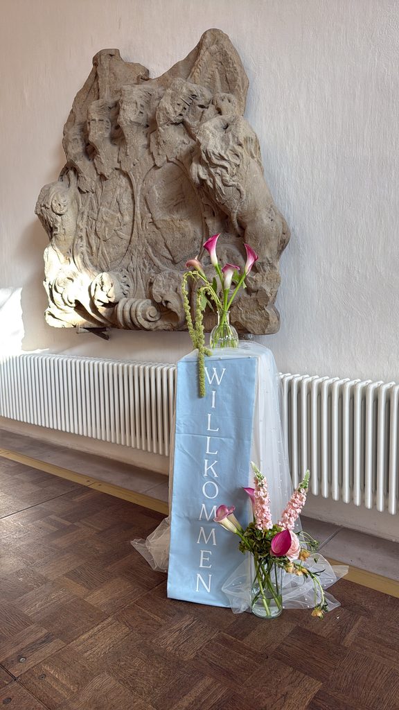 Florale Willkommensdekoration mit pinkfarbenen Callas und Willkommensschild im Schloss Hemhofen
